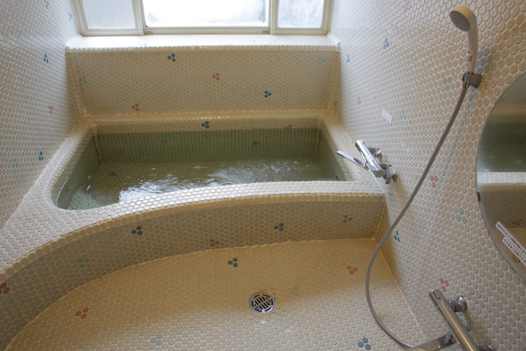 Large Japanese style tiled bath and shower area.