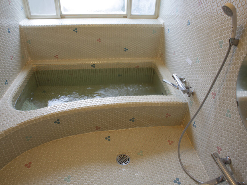 Large Japanese style tiled bath and shower area.